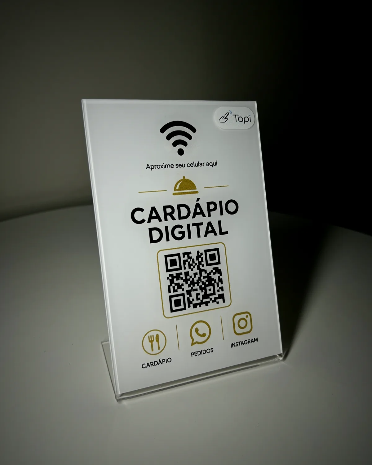 Plaquinha de acrílico da Tapi apoiada em uma mesa, pronta para uso
